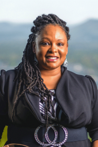 A woman wearing a black blouse smiling at the camera.